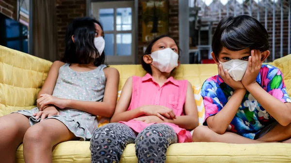 Crianças Sudeste Asiático Vestindo Máscara Facial Médica Sentadas Sofá Juntas — Fotografia de Stock
