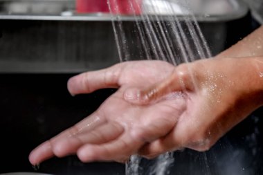Yakından bakınca Eller 'in temizlik ve sağlık hizmetlerini korumak için mutfak lavabosunda su altında yıkandığı görüntüsü bulanıklaşıyor. Sağlıklı yaşam tarzı.