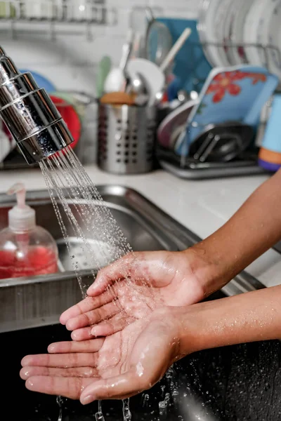 手の閉鎖イメージ清潔さと医療を維持するためにキッチンシンク上の水のシャワーの下で洗浄されています 健康的なライフスタイル — ストック写真