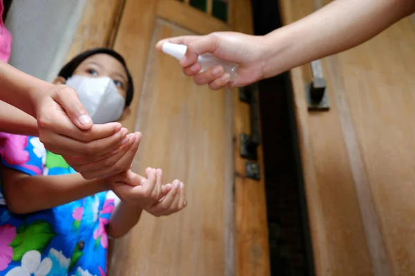东南亚小孩的手在进屋前被母亲用手部清洁剂喷了一下 预防传染病卫生和健康的生活方式 有选择地关注孩子们的双手 — 图库照片