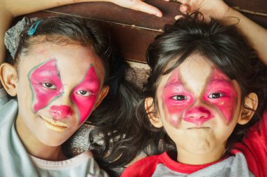 Güneydoğu Asyalı çocuklar yüzlerini palyaço karakteriyle örterler. Birlikte eğleniyoruz.