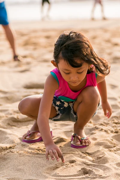 Liten flicka skriver om beach sanden — Stockfoto