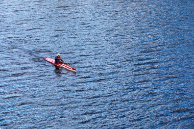 Macaristan Budapeşte 22 Ekim 2020: Kimliği belirsiz adam sakin suda tek koltuklu kano kullanıyor - üst manzara. 