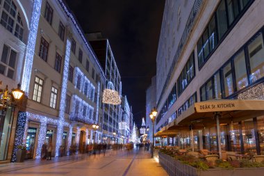 Budapeşte, Macaristan - 15 Aralık 2019: Turistler Budapeşte 'nin aşağısındaki Noel ruhu ve ışık gösterisinin tadını çıkarıyorlar. Bu geleneksel Noel fuarı her yıl bir milyondan fazla ziyaretçiyi çekiyor..