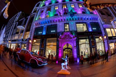 Budapeşte, Macaristan - 15 Aralık 2018: Noel Baba 'nın yeni arabası. Turistler Noel ruhunun ve Budapeşte 'nin aşağısındaki ışık gösterisinin tadını çıkarıyorlar. Bu geleneksel Noel fuarı her yıl bir milyondan fazla ziyaretçiyi çekiyor..