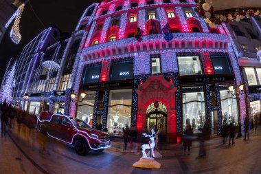 Budapeşte, Macaristan - 15 Aralık 2018: Noel Baba 'nın yeni arabası. Turistler Noel ruhunun ve Budapeşte 'nin aşağısındaki ışık gösterisinin tadını çıkarıyorlar. Bu geleneksel Noel fuarı her yıl bir milyondan fazla ziyaretçiyi çekiyor..