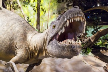 Yeşil arka planı olan beyaz bir dinozorun yakın plan fotoğrafı.