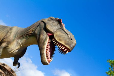 Büyük bir dinozor yeşil çimlerin üzerinde duruyor..