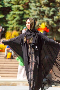 Calgary, Kanada - 10 Ağustos 2014: Olympic Plaza 'da halka açık alanda Arap tarzı moda gösteren model. 