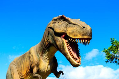 Yeşil çimlerin üzerinde bir dinozor.