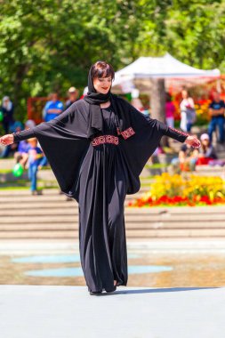 Calgary, Kanada - 10 Ağustos 2014: Olympic Plaza 'da halka açık alanda Arap tarzı moda gösteren model. 