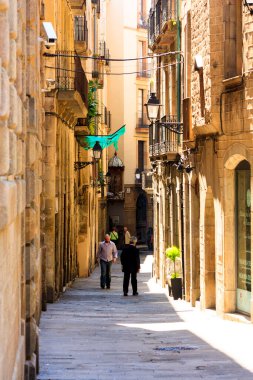 Güneşli bir günde eski caddede yürüyen insanların manzarası 