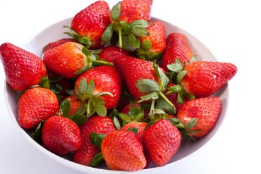 Beyaz arka planda bir kasede taze çilek.