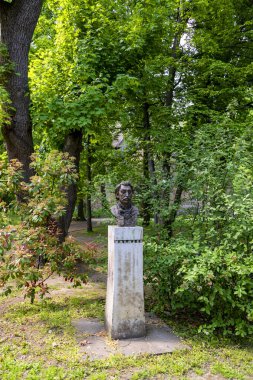 Güneşli bir günde parkta eski bir insan heykeli 