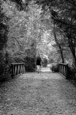 Ormanda yürüyen ceketli bir kadın.