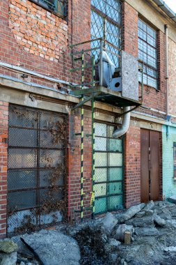 Büyük pencereleri ve rıhtım kapıları olan eski bir deponun tuğla döşeme taşlarının zemin katı manzarası..