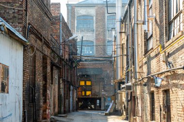 Büyük pencereleri ve rıhtım kapıları olan eski bir deponun tuğla döşeme taşlarının zemin katı manzarası..