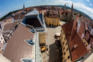 Çatıları ve mavi gökyüzü arkaplanı olan şehir manzarası