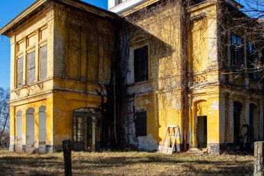Şehirde terk edilmiş bir ev, çırılçıplak dallarla.