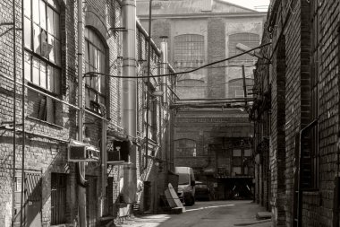 Büyük pencereleri ve rıhtım kapıları olan eski bir deponun tuğla döşeme taşlarının zemin katı manzarası..