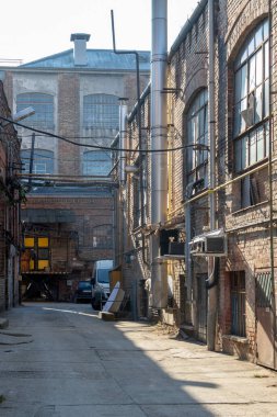 Büyük pencereleri ve rıhtım kapıları olan eski bir deponun tuğla döşeme taşlarının zemin katı manzarası..