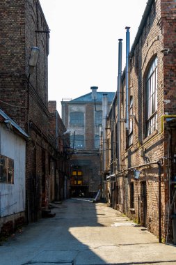 Büyük pencereleri ve rıhtım kapıları olan eski bir deponun tuğla döşeme taşlarının zemin katı manzarası..