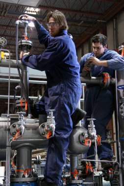 Fabrikada çalışan üniformalı işçiler.