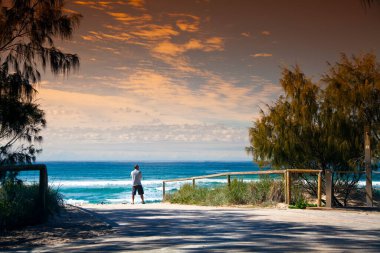 Manzaralı deniz manzarası. Denizin önünde duran bir adam.