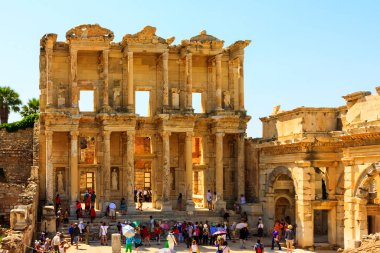   tourists walking near ancient Roman building Library of Celsus, Ephesus, Turkey