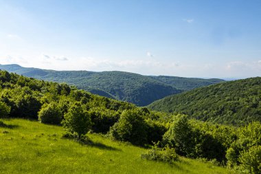 Dağları ve mavi gökyüzü olan güzel bir manzara.