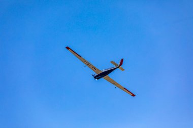 Mavi gökyüzünün arka planında bir uçak uçuyor..