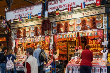 Şehirdeki pazarda tezgahların yanında yürüyen turistler  