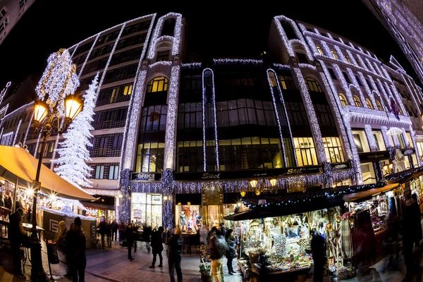 Les touristes apprécient l'esprit de Noël et le spectacle de lumière dans le centre-ville de Budapest . — Photo