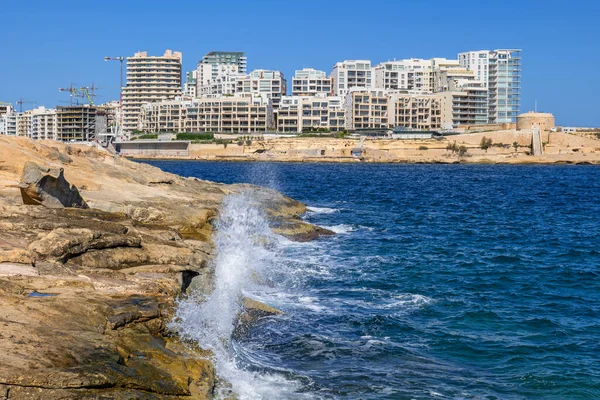 マルタのスライマリゾートタウンスカイライン バレッタ市の下の岩の海の海岸からの眺め — ストック写真