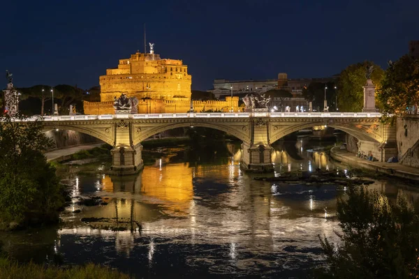 イタリアのローマのティバー川での夜 サンタンジェロ城 聖天使の城 とポンテ ヴィットリオ エマヌエーレ2世橋への眺め 水面の光の反射 — ストック写真