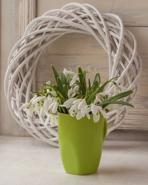 Bouquet of snowdrops in green cup — Stock Photo, Image