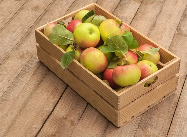 Krabice z jablek na dřevěný stůl — Stock fotografie