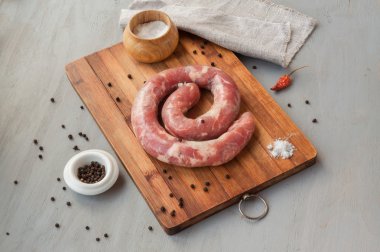Yüzük kesme tahtası üzerinde çiğ sosis