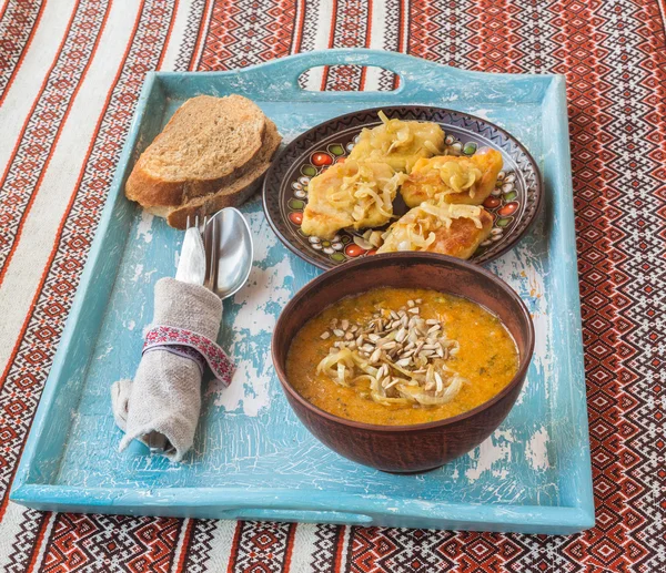 Brambory se smaženou cibulkou a Dýňová polévka na talíři — Stock fotografie