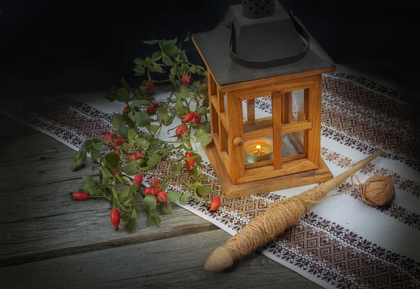 Branch of wild rose and wooden lantern — Stock Photo, Image