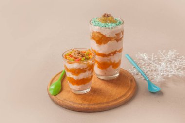 Gri arka planda şeffaf gözlüklü hurma ağacıyla süzme peynir ve yoğurt tatlısı.