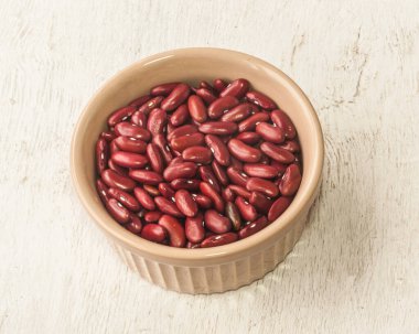 Mutfak masasındaki seramik kasede çiğ fasulye. Düz yatıyordu