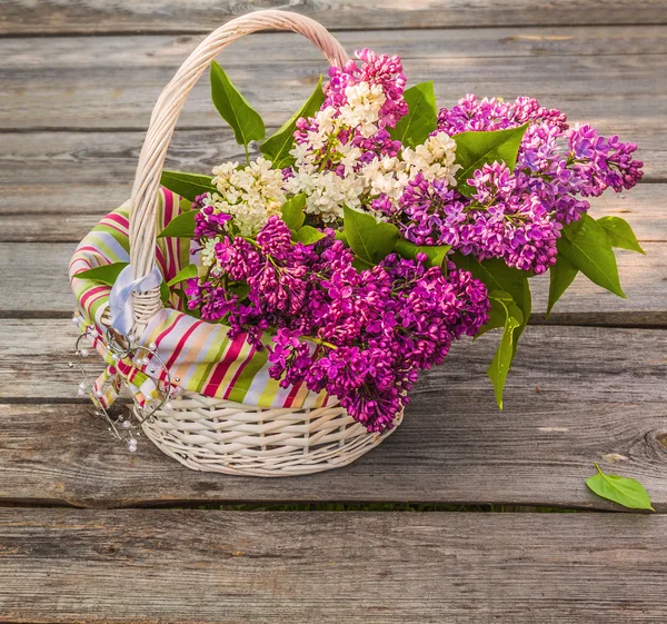 Basket with a branch of lilac — Stock Photo, Image