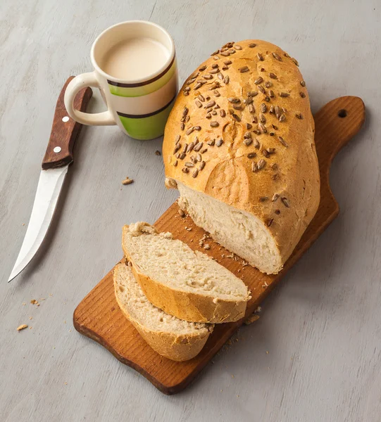 Loaf of rye bread and cup of milk — Stock Photo, Image