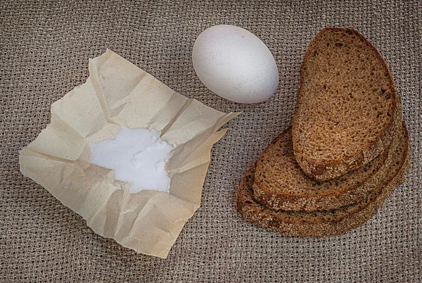Rye bread, egg and salt on canvas — Stock Photo, Image