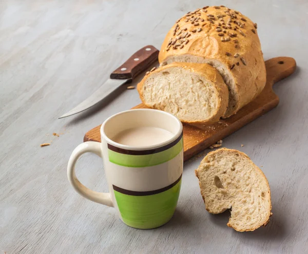 Loaf of rye bread and cup of milk — Stock Photo, Image
