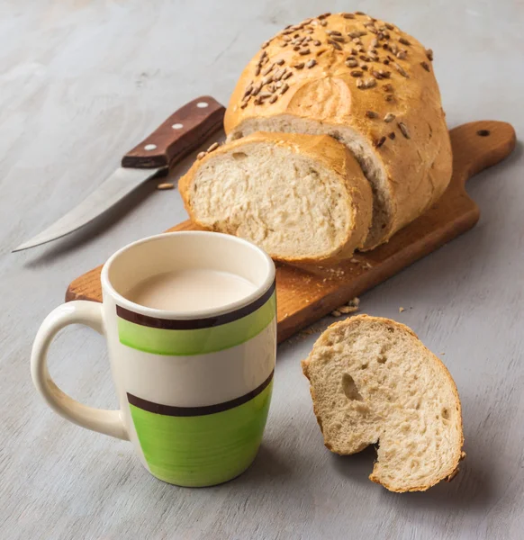 Laib Brot und eine Tasse Milch — Stockfoto