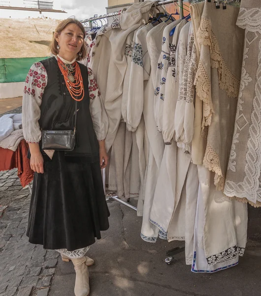 Kobieta sprzedaje rocznika Haftowane koszule. — Zdjęcie stockowe