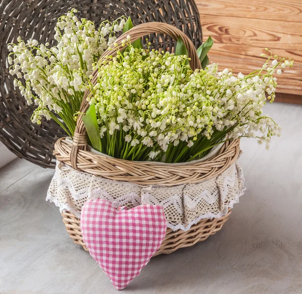 Basket with lilies of the valley and heart — Stock Photo, Image