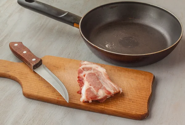 Schweinefleisch auf ein Schneidebrett und pan — Stockfoto